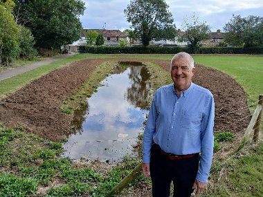 Cllr Eddie Lavery stands next to the flood alleviation 'swale' in Bessingby Park, Ruislip