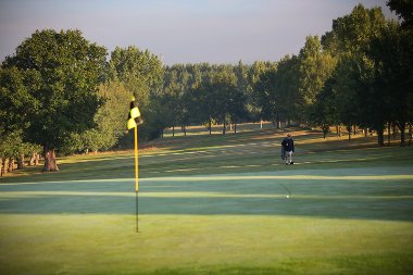 General view of Uxbridge Golf Course with a green in the foreground and a player approaching down the fairway