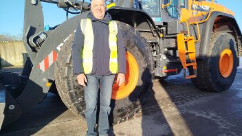 Cllr Eddie Lavery stands in front of a new Develon shove at the Harefield Civic Amenity Site.