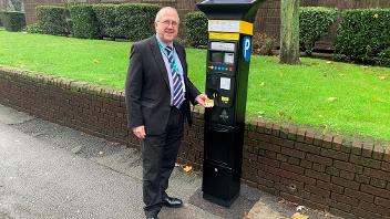 Councillor Burrows standing in front of a new parking machine
