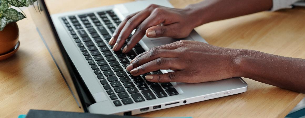 Hands of young woman typing on laptop